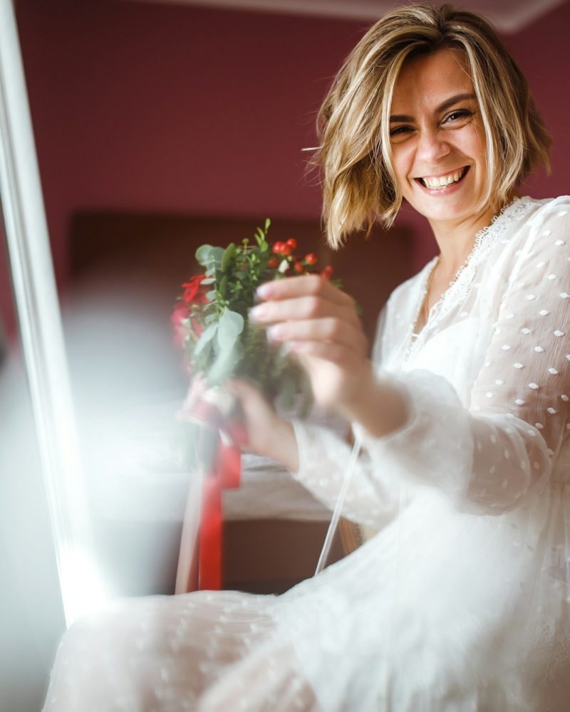 Beautiful bride with wedding flowers bouquet in white luxury dress is getting ready for wedding.